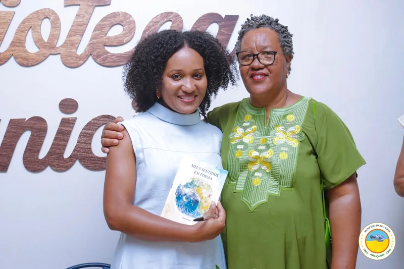 Alissa Mendes com a apresentadora, segurando um exemplar assinado