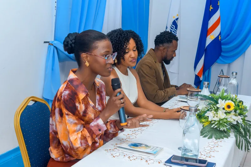 Evelise Carvalho a apresentar, com a bandeira de Cabo Verde ao fundo